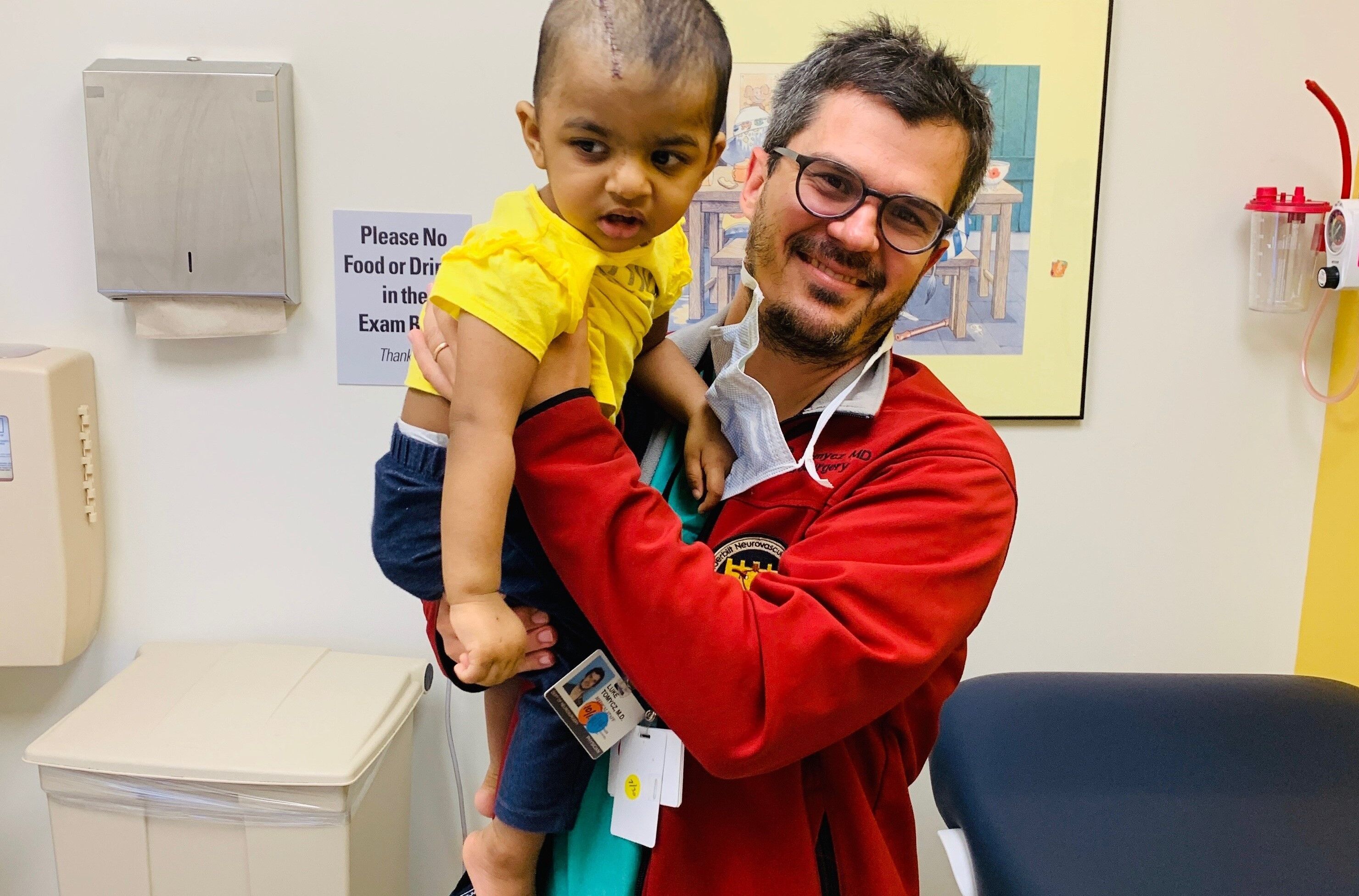 Photo of Dr. Luke Tomycz holding recovering patient